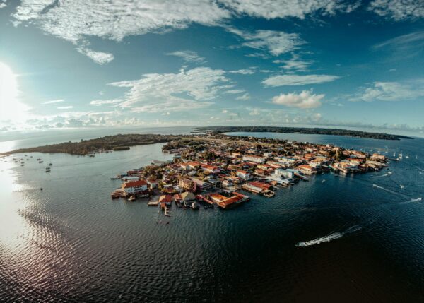 Captivating aerial view of a vibrant island town surrounded by sparkling blue waters under a clear sky.