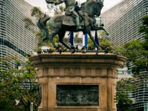 Equestrian statue at Plaza Gerardo Barrios with backdrop of modern architecture in San Salvador.