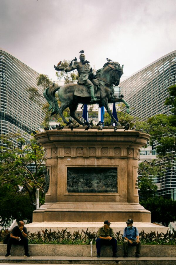 Equestrian statue at Plaza Gerardo Barrios with backdrop of modern architecture in San Salvador.