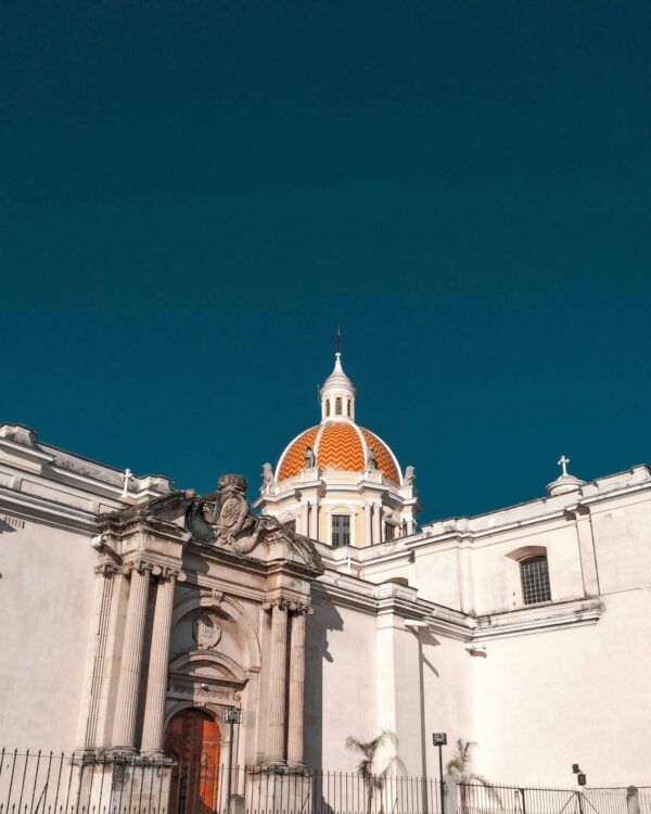 Explore the stunning architecture and iconic dome of Guatemala City under a clear blue sky.