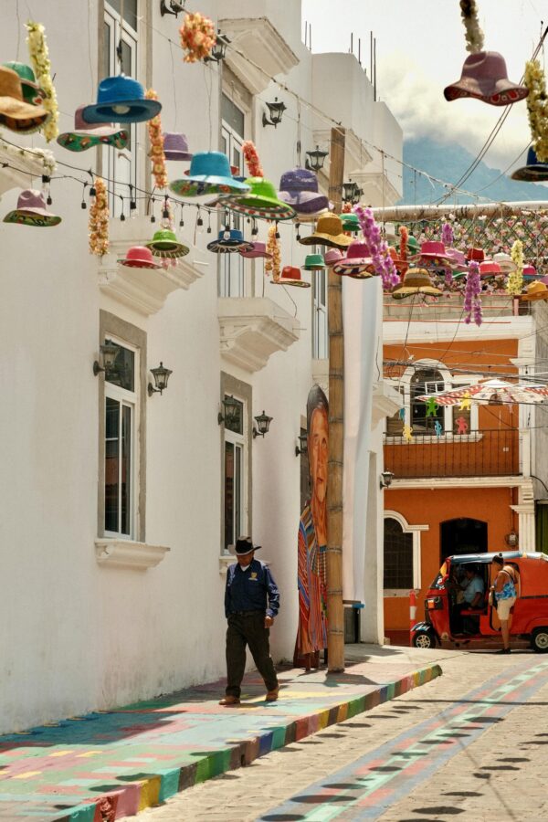 Vibrant street with hanging hats in Sololá, Guatemala, showcasing local culture.